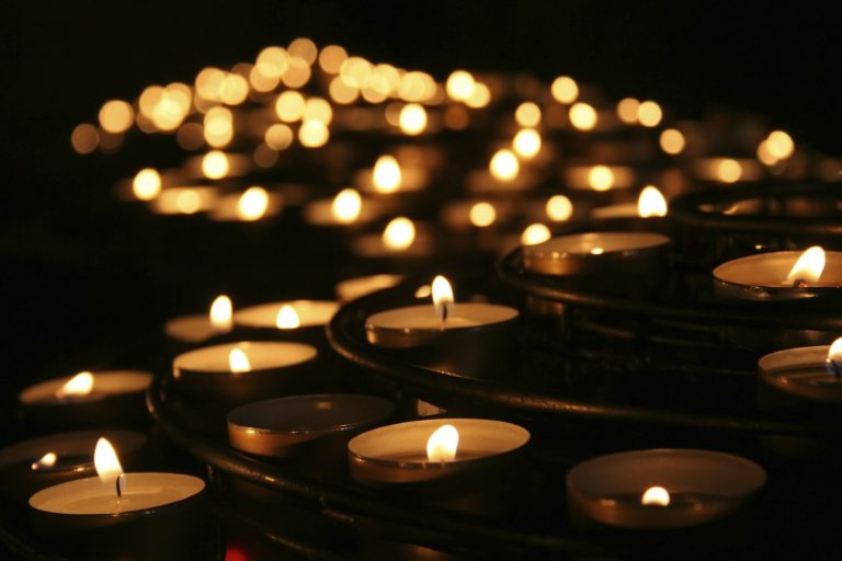 Viele kleine Teelichter die im Hintergrund zu einem Lichtermeer verschwimmen, Symbol der Feuerbestattung von Lilium Bestattungen Hamburg
